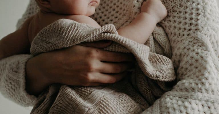 mom holding a baby in a blanket