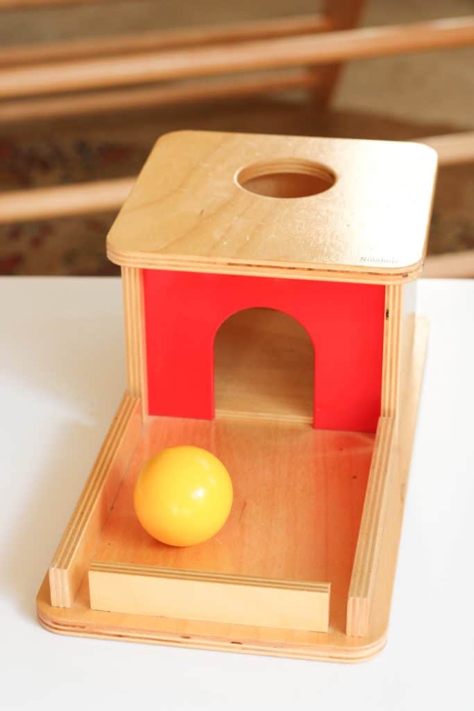 Montessori object permanence box with a wooden ball
