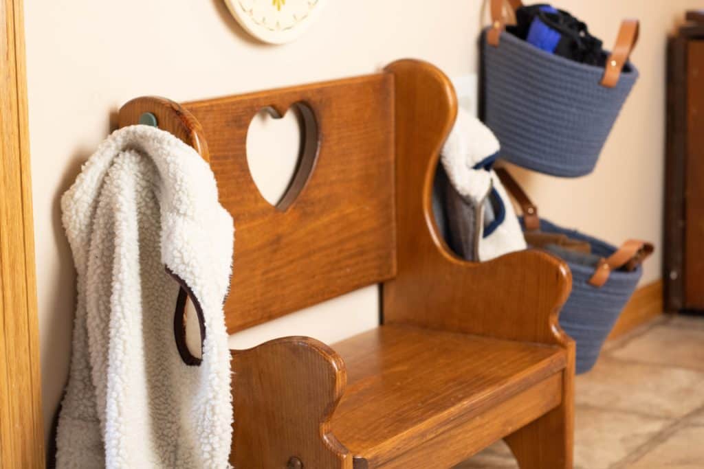 small bench with jacket hanging on a hook in a Montessori entryway