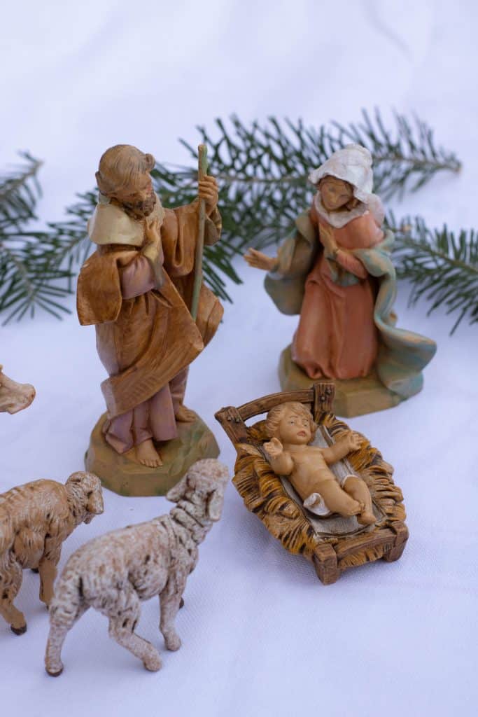 Close up of a nativity set with Mary, Joseph, baby Jesus in a manger and some animals. 