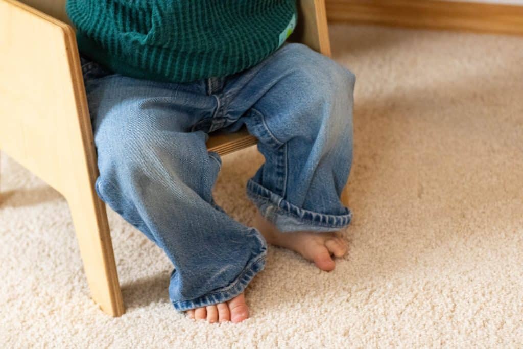 Close up of a baby sitting in a small chair
