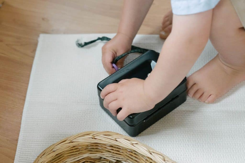 A toddler opening a lockbox.