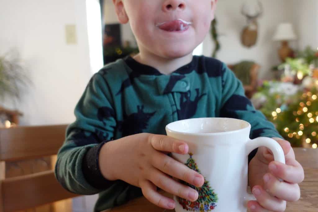 Child drinking hot cocoa.