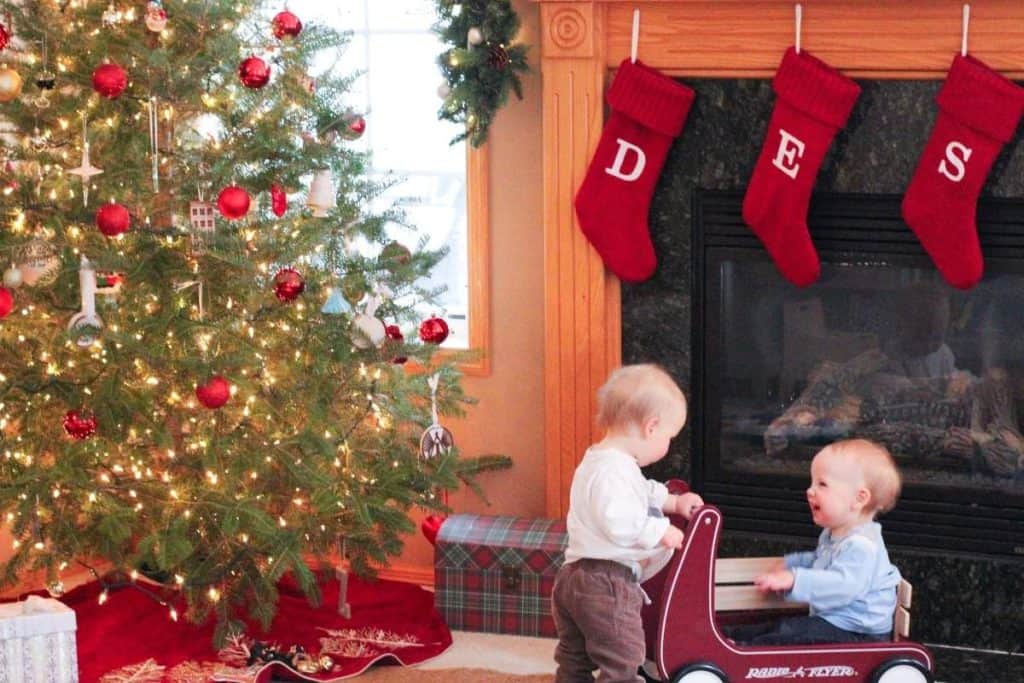 Twins in front of a Christmas tree.