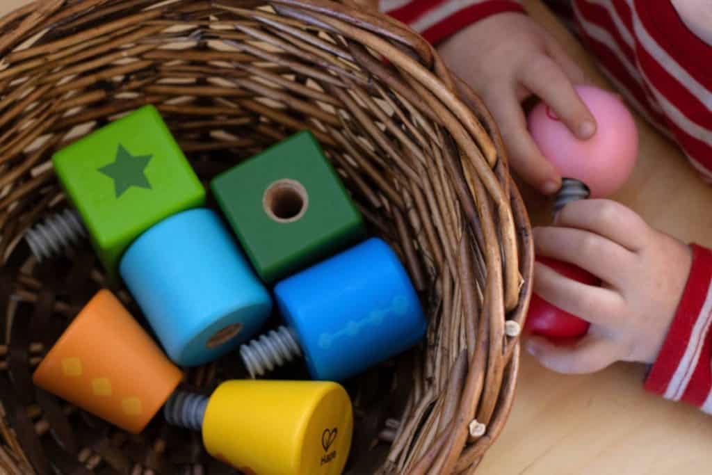 Toddler hands twisting a puzzle together.
