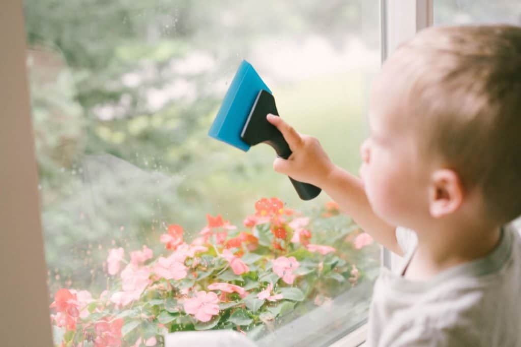 Young child washing windows