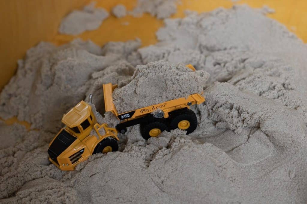 Toy dump trick sitting in kinetic sand.