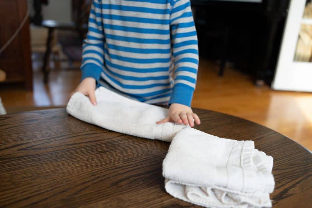 Child folding towels.