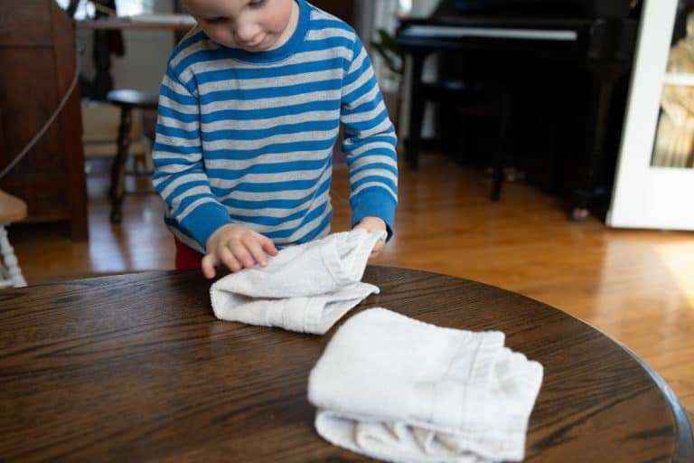 Child folding towels.