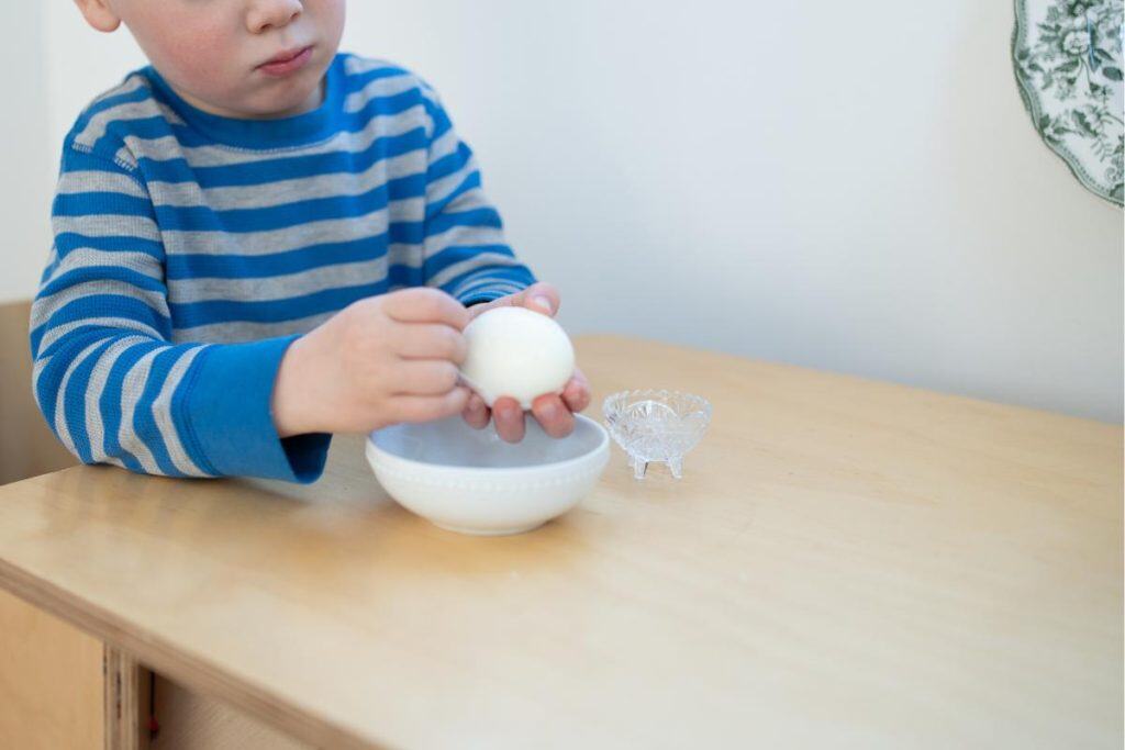 Child peeling a hard-boiled egg.