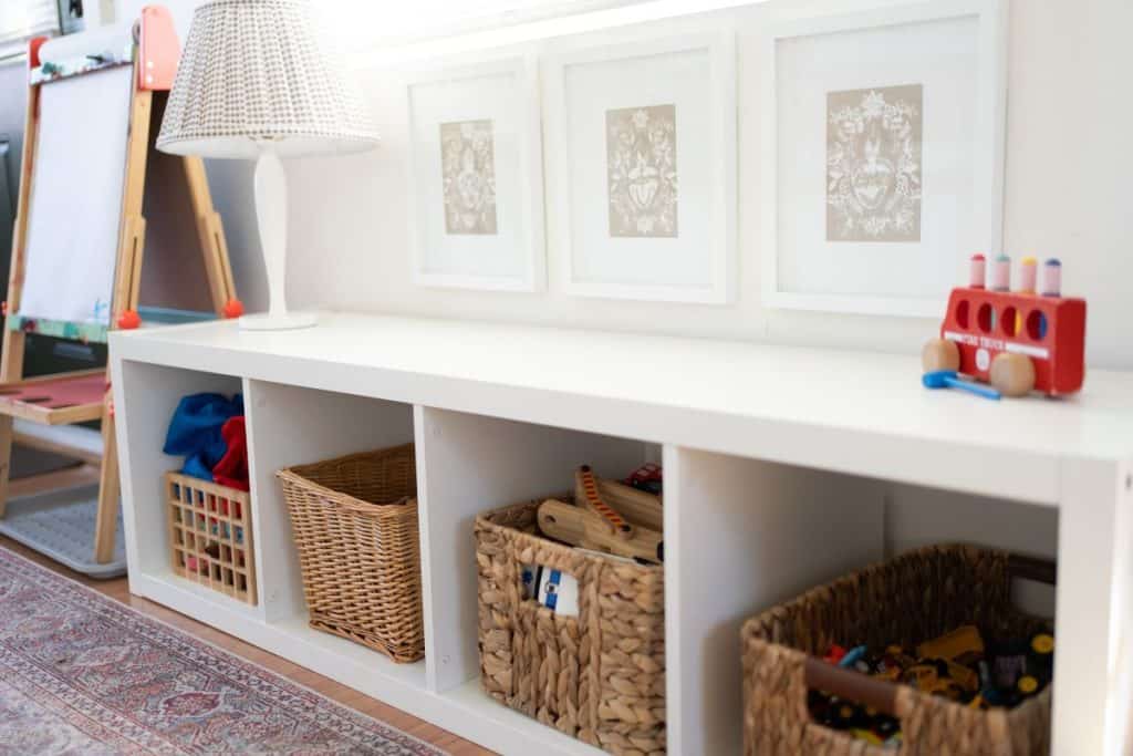 Shelf with toys and artwork hung above.